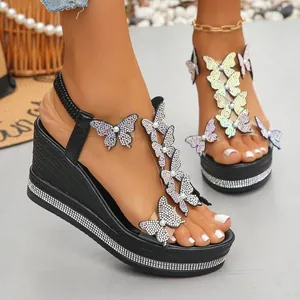 Elegant black wedge sandals with rhinestone butterfly details and sparkling platform sole.