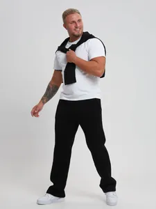 Full body studio shot of a male model wearing black straight-leg cotton casual joggers