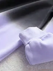 Detailed macro view showing the ribbed elastic cuff on a purple gradient tie-dye hoodie