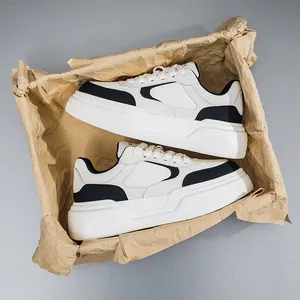 Vue détaillée de baskets compensées homme noir et blanc en emballage papier.