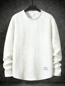 Detailed view of white round neck pullover sweatshirt with rich textured patterns