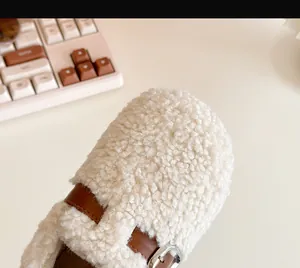 Close-up macro detail of cozy kids shearling winter shoes with brown leather H-strap buckle