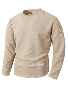 Detail of beige long sleeve crewneck sweater with diamond textured knit pattern