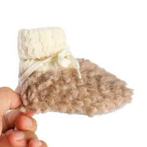 Macro shot of cozy brown fleece-lined baby winter sock shoe with white knitted cuff