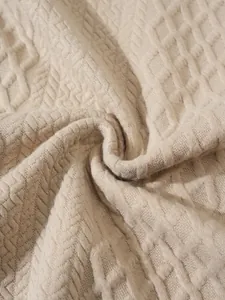 Macro view of textured diamond pattern beige knitted fabric showing soft wool material