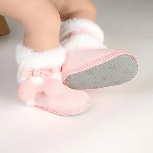 Détail des bottes d'hiver roses pour bébé avec semelles antidérapantes et fourrure.