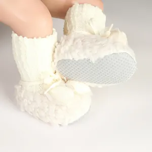 Detail view of plush baby winter sock shoes with anti-slip dotted sole for newborns