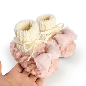 Close-up detail of soft pink fluffy baby winter sock shoes with tulle bow design
