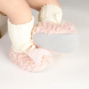 Close-up of anti-slip sole and decorative bow on pink baby fleece bootie shoes