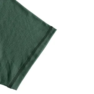 Macro detail of the durable stitching on a dark green men's cotton T-shirt sleeve