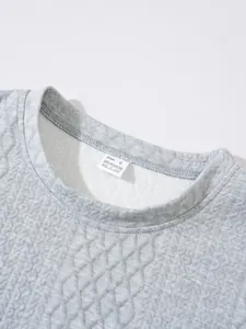 Close-up of crew neckline and care label on a grey quilted textured casual sweatshirt