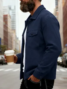 Gros plan sur une veste bleu marine à revers et doubles poches poitrine, coupe slim