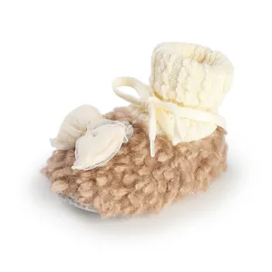 Macro view of warm cozy baby girl winter fleece shoe with soft knitted bow detail