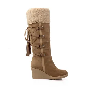 Side view of tan high-top snow boots with faux fur lining and wedge heel detailing