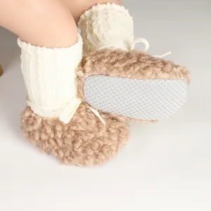 Detail view of baby winter plush booties showing the grey anti-slip dotted sole design