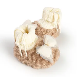 Macro shot of plush fleece texture and white lace bow on newborn winter booties