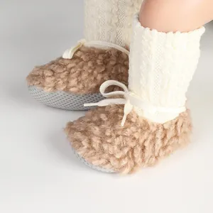 Close-up of fuzzy baby winter sock shoes with knit ribbing and adjustable drawstring