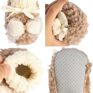 Close-up of soft plush baby shoes with bow detail and non-slip sole.