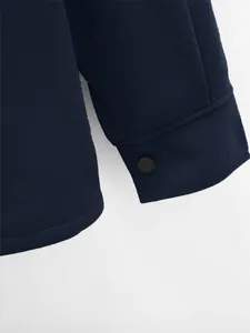 Gros plan du poignet d'une veste bleu marine pour homme avec bouton-pression noir mat