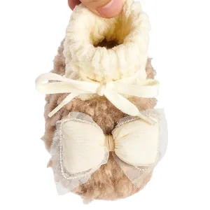 Detailed view of warm plush baby winter bootie featuring cream knit cuff and large bow