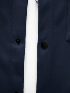 Détail de la fermeture à boutons et du tissu texturé bleu marine d'une veste cintrée pour homme