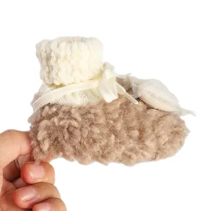 Close-up of baby winter bootie with cream knit top and brown fuzzy shearling detail