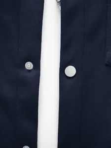 Détail d'une veste bleu marine à coupe ajustée avec bouton-pression et texture tricot