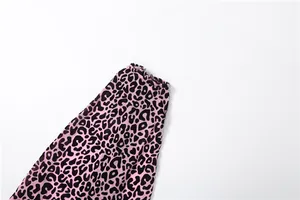 Détail du tissu à motif léopard rose et noir sur une combinaison sexy à licou.