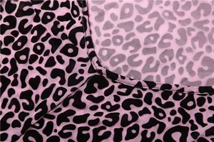 Détail du tissu en maille rose à motif léopard montrant des coutures fines et texture