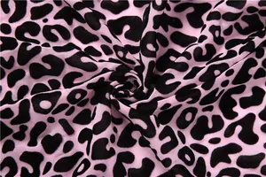 Vue détaillée du tissu en maille rose présentant un motif léopard noir audacieux pour vêtements