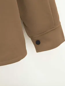 Vue détaillée de la manchette d'une veste marron pour homme avec un bouton noir.