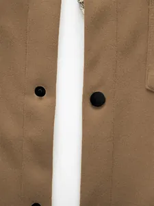 Vue rapprochée d'une veste cintrée marron avec boutons noirs et texture du tissu