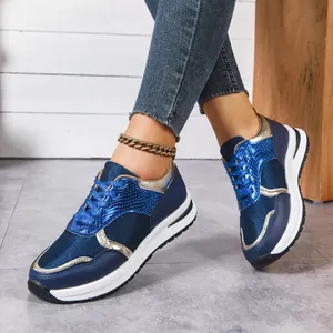 Gros plan détaillé de baskets compensées bleu marine et or aux pieds du mannequin