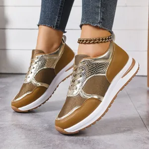 Vue détaillée de baskets à semelle épaisse marron et or portées avec un jean.