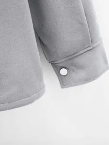 Gros plan de la manche d'une veste en velours côtelé gris montrant la texture fine