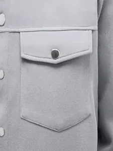 Detailopname van een grijs herenjack met zakflap en hoogwaardige textuur van de stof.