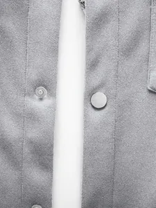Détail en gros plan de la fermeture à bouton-pression en métal et du tissu gris