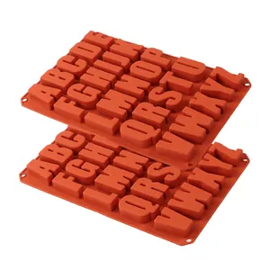 Primo piano di due stampi in silicone arancione a 26 lettere per cioccolato.