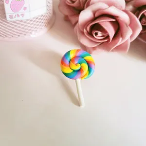 Detailed view of a colorful rainbow polymer clay lollipop brooch for bags.