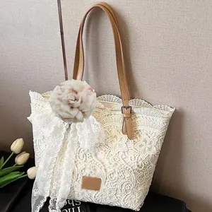 Dettaglio di una grande spilla a forma di peony in tessuto bianco su borsa di pizzo