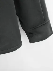 Gros plan sur le poignet d'une veste pour homme gris foncé avec bouton-pression noir