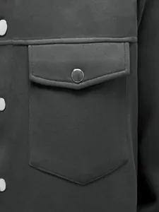 Detailweergave van een herenjas in donkergrijs met een zak en een drukknoopsluiting.