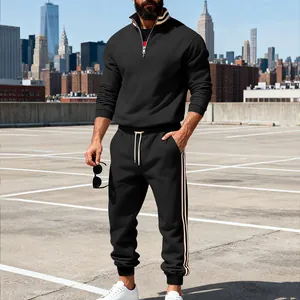 Full body lifestyle view of black tracksuit with striped trim on an urban rooftop