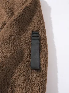 Nahaufnahme der braunen Sherpa-Fleece-Textur und der schwarzen Riemendetails am Herren-Hoodie