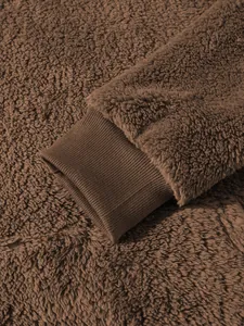 Detail der gerippten Manschette an braunem Sherpa-Fleece-Herren-Hoodie mit Textur.