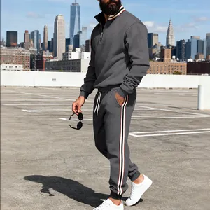 Detail view of men's grey heavy tracksuit featuring side contrast stripes and half-zip
