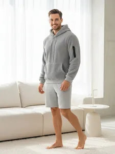 Nahaufnahme eines Mannes in einem grauen Fleece-Kapuzenpullover in moderner Wohnumgebung