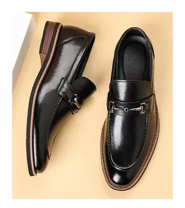 Top view detail of black men's leather loafers featuring a polished metal horsebit buckle