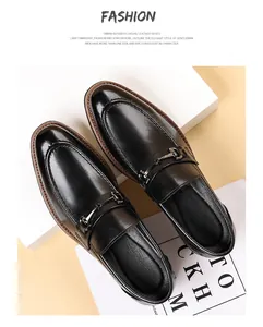 Detailed close-up of black leather loafers with metal buckle detail and polished finish.