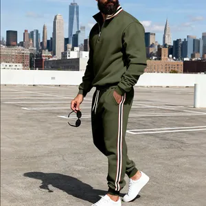Full length view of men's olive green tracksuit with side stripe detail in urban setting